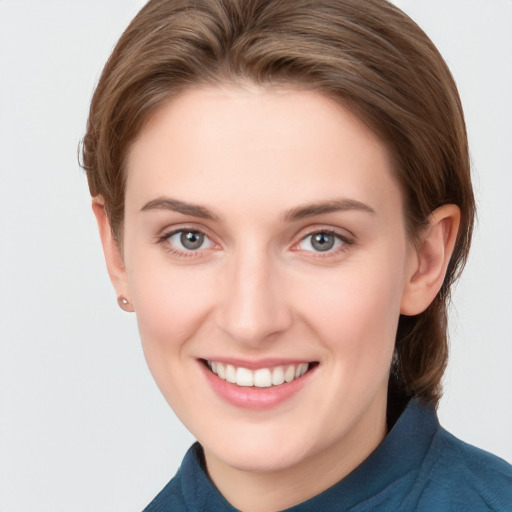 Joyful white young-adult female with medium  brown hair and grey eyes