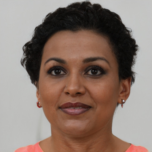 Joyful black adult female with short  brown hair and brown eyes