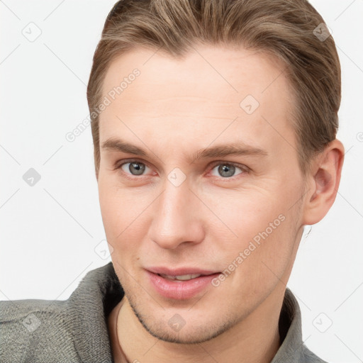 Joyful white young-adult male with short  brown hair and grey eyes