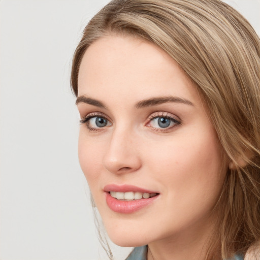 Joyful white young-adult female with long  brown hair and blue eyes