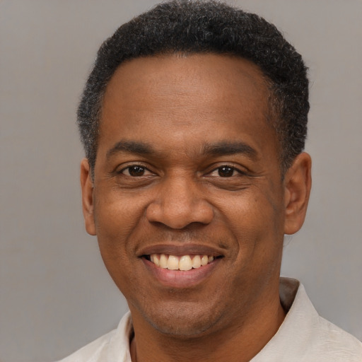 Joyful black young-adult male with short  black hair and brown eyes