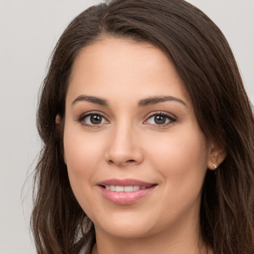 Joyful white young-adult female with long  brown hair and brown eyes