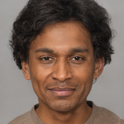 Joyful black adult male with short  brown hair and brown eyes