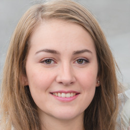 Joyful white young-adult female with long  brown hair and green eyes