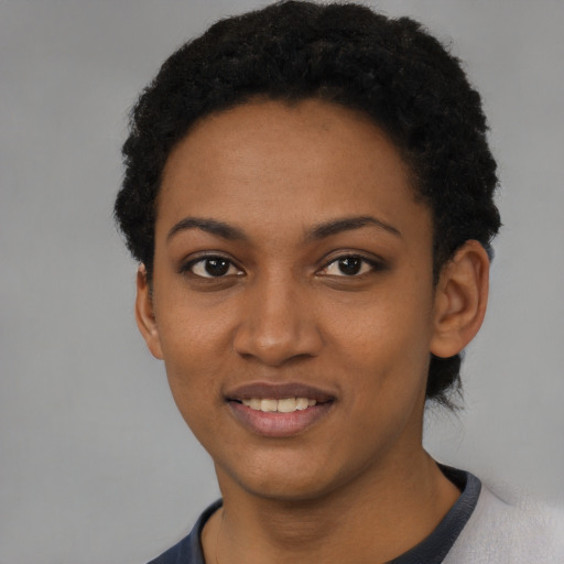 Joyful black young-adult female with short  black hair and brown eyes