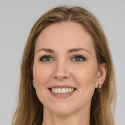 Joyful white young-adult female with long  brown hair and green eyes