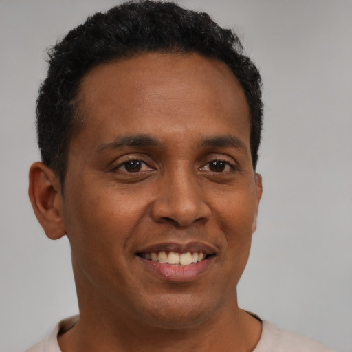 Joyful black young-adult male with short  brown hair and brown eyes