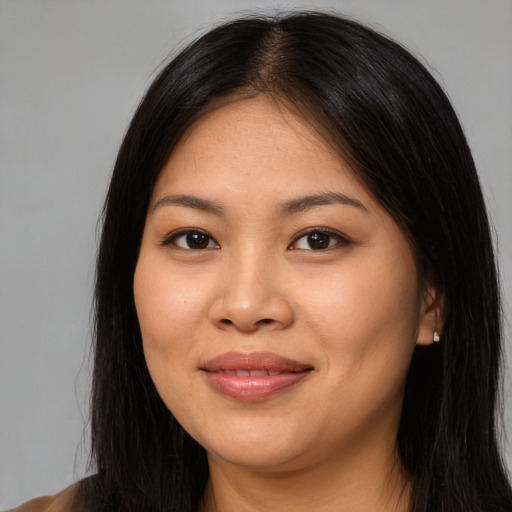Joyful asian young-adult female with long  brown hair and brown eyes