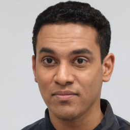 Joyful latino young-adult male with short  black hair and brown eyes