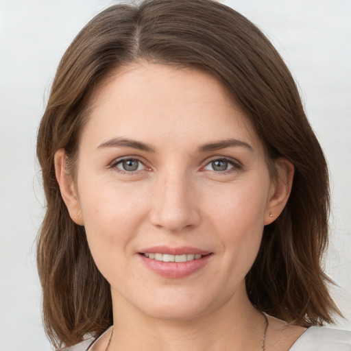 Joyful white young-adult female with medium  brown hair and grey eyes