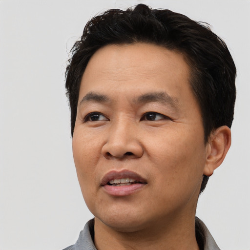 Joyful asian adult male with short  black hair and brown eyes