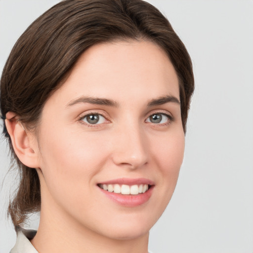 Joyful white young-adult female with medium  brown hair and green eyes