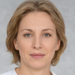 Joyful white adult female with medium  brown hair and grey eyes