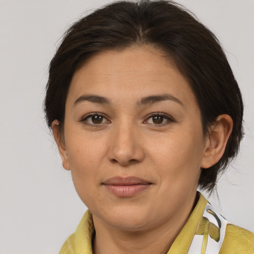 Joyful latino adult female with medium  brown hair and brown eyes