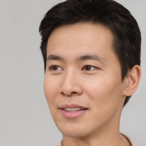 Joyful asian young-adult male with short  brown hair and brown eyes