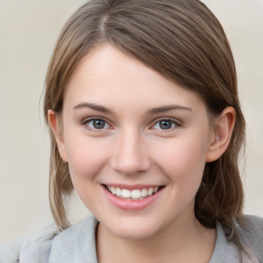 Joyful white young-adult female with medium  brown hair and grey eyes