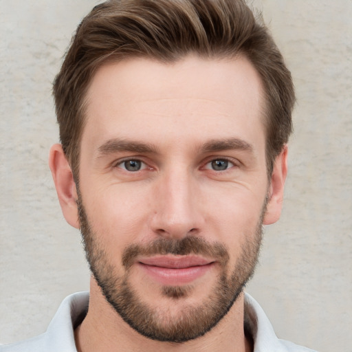 Joyful white young-adult male with short  brown hair and grey eyes