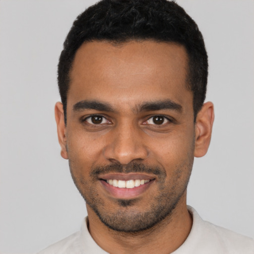 Joyful latino young-adult male with short  black hair and brown eyes