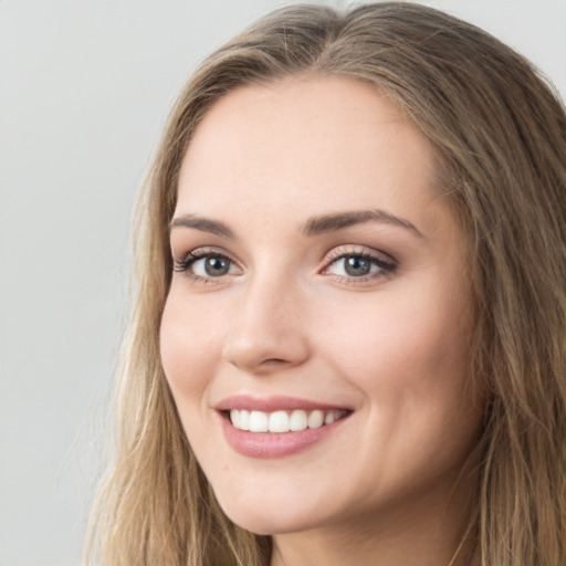 Joyful white young-adult female with long  brown hair and green eyes