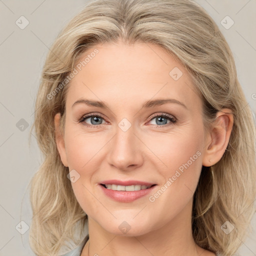 Joyful white adult female with medium  brown hair and blue eyes