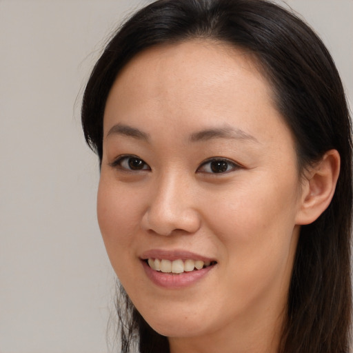 Joyful asian young-adult female with long  brown hair and brown eyes