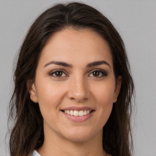 Joyful white young-adult female with long  brown hair and brown eyes