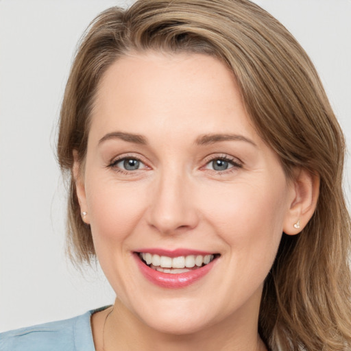 Joyful white young-adult female with medium  brown hair and grey eyes