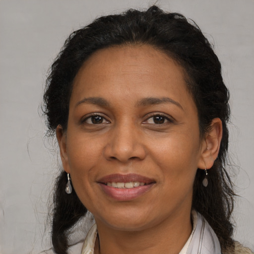 Joyful latino adult female with medium  brown hair and brown eyes