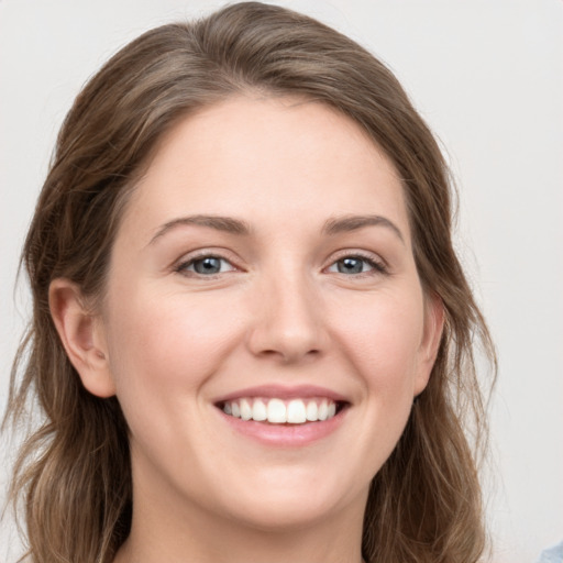 Joyful white young-adult female with long  brown hair and grey eyes