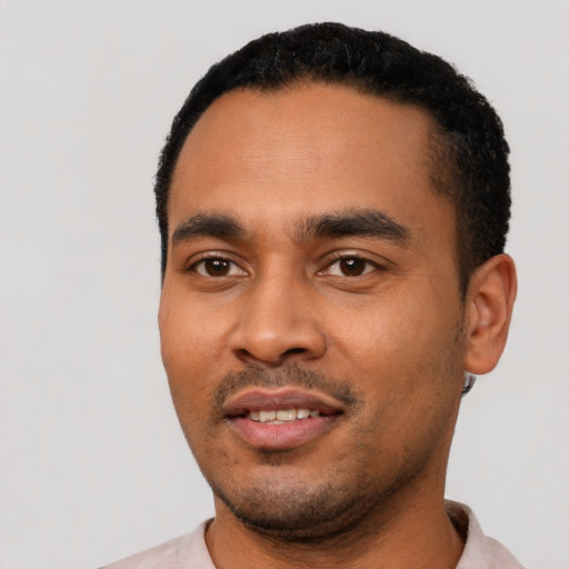 Joyful latino young-adult male with short  black hair and brown eyes