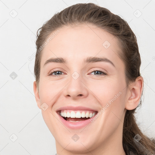 Joyful white young-adult female with long  brown hair and grey eyes