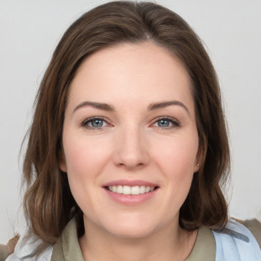 Joyful white young-adult female with medium  brown hair and grey eyes