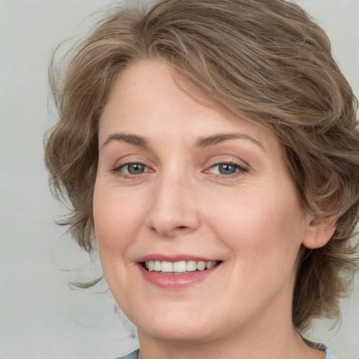 Joyful white young-adult female with medium  brown hair and green eyes