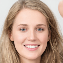 Joyful white young-adult female with long  brown hair and blue eyes