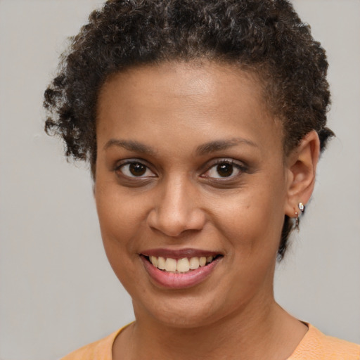 Joyful black young-adult female with short  brown hair and brown eyes
