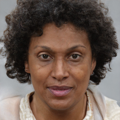 Joyful black adult female with medium  brown hair and brown eyes