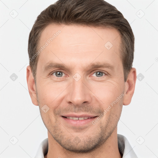 Joyful white young-adult male with short  brown hair and grey eyes