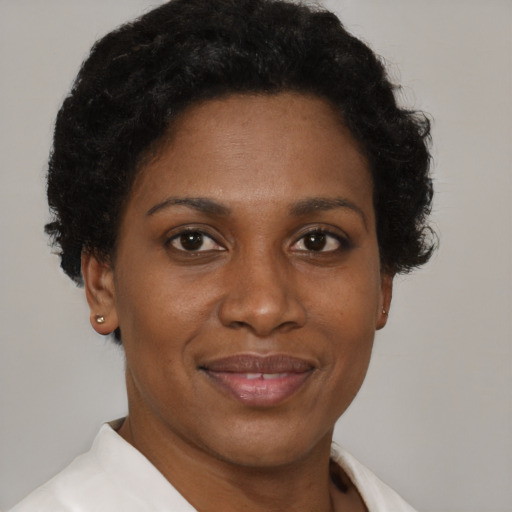 Joyful black adult female with short  brown hair and brown eyes