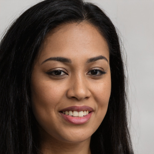 Joyful latino young-adult female with long  brown hair and brown eyes