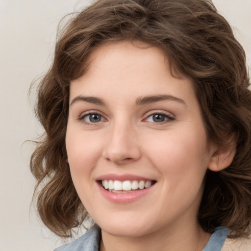 Joyful white young-adult female with medium  brown hair and green eyes