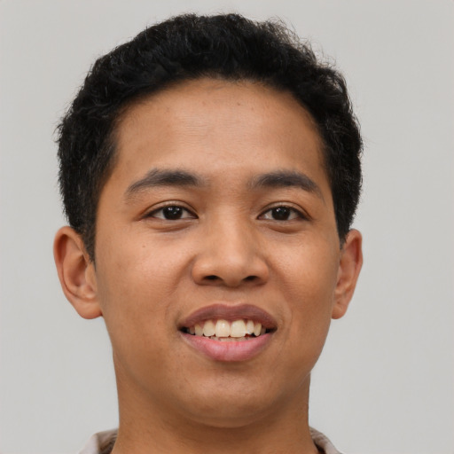 Joyful latino young-adult male with short  brown hair and brown eyes