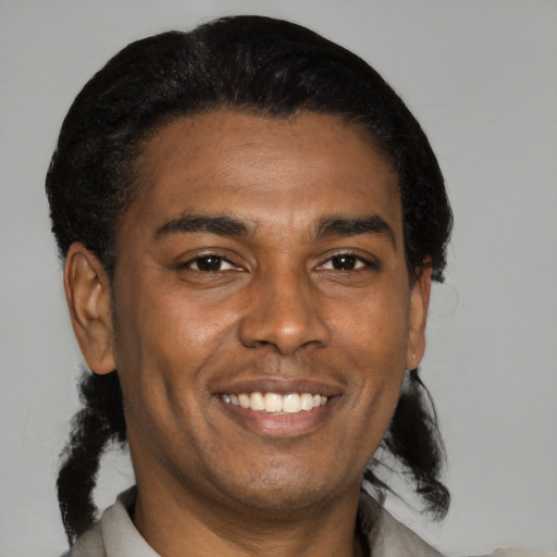 Joyful black young-adult male with medium  black hair and brown eyes
