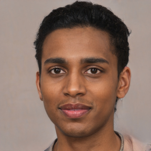 Joyful black young-adult male with short  black hair and brown eyes