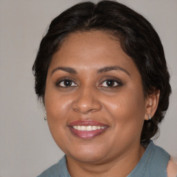 Joyful black adult female with medium  brown hair and brown eyes