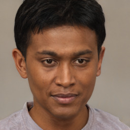 Joyful latino young-adult male with short  brown hair and brown eyes