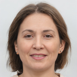 Joyful white adult female with medium  brown hair and grey eyes