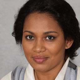 Joyful black adult female with medium  brown hair and brown eyes