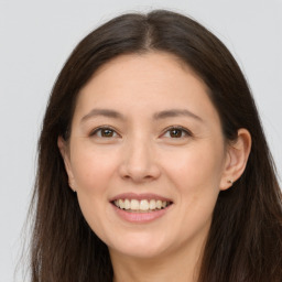 Joyful white young-adult female with long  brown hair and brown eyes