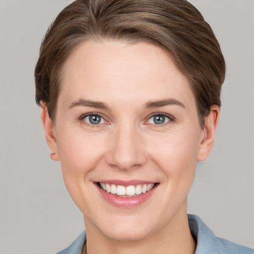 Joyful white young-adult female with short  brown hair and grey eyes