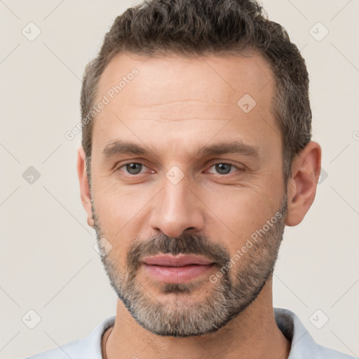 Joyful white adult male with short  black hair and brown eyes